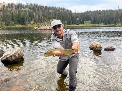 CHIEF founder holding cutthroat trout in OutCast Sun Hoodie, CHIEF Glitch Logo Hat, and QuickDraw Pants